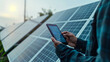 © Maksym - Close-up: Energy analyst at solar station, tablet displaying energy graphs.