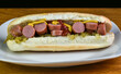 hot dogs in a sub roll with mustard and  relish,