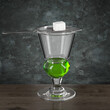 Absinthe glass on a wooden table against a grunge style wall. Bar theme. Drink with sugar on a spoon. Dark environment. 3d rendering.