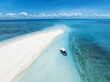 Aerial view of Nakupenda island, sandbank in ocean, empty white sandy beach, boat, blue sea during low tide at sunny summer day in Zanzibar. Top view of sand spit, clear water, sky. Tropical scenery