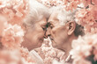 Senior couple surrounded by beautiful flowers are kissing