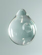 
a drop of gel falling from above, air bubbles inside, with soft blue colors, roundness, 3D, and a mature material texture grey background