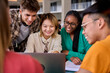 Group of diverse multiethnic smiling young students using laptop studying gathering in classroom. Academics multiracial people classmates working in a project creative inside of university building