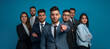 © Favio - Group of seven hispanic business people in suits, one man pointing at camera on blue background.