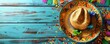 © Margarita Ratatosk - Mexican sombrero on blue wooden background with confetti and paper flags. Mariachi hat and striped poncho. Cinco de mayo festival. Hispanic heritage month. Flat lay, top view with copy space