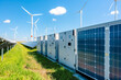 © MVProductions - Modern battery energy storage system with wind turbines and solar in grass fields