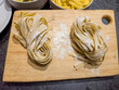 Two bundles of fresh handmade pasta on a wooden cutting board