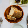 Rustic sourdough bread in a wooden bowl on a restaurant table
