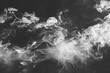 swirling tendrils of white smoke on black background abstract photography