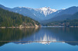 © maxdigi - Capilano Lake Lions Peaks Reflection North Vancouver. The view of the Lions high over the Capilano Lake Reservoir in Capilano River Regional Park, North Vancouver, British Columbia.