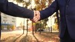 Business woman shaking hands with partner, outdoors. Businessmen in suits greet on street with hand gestures. Business people shaking hands teamwork. Successful cooperation under contract. Politicians