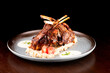grilled rack of lamb with potatoes on wooden table on dark background