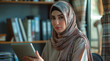 © Paradoxx - Woman in hijab using a tablet computer in a library. Generative AI