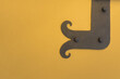 Forged vintage metal hinges on a yellow wall.copy space.