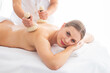 © Acronym - Young woman getting massaging treatment over white. Spa, healthcare and recreation concept.