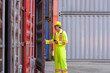 Asian engineer in helmet and uniform working on container cargo inspection  at shipping yard.