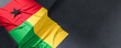 Flag of Guinea Bissau. Fabric textured Guinea Bissau flag isolated on dark background. 3D illustration