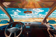Stunning view from car front seat on a sandy beach with a sunny sky.