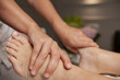 © Oksana - Massage therapist doing foot and leg massage with hands