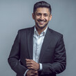 © Tony Noel - Young indian asian man wearing black suit and white shirt over isolated grey or white background happy face smiling with crossed arms looking at the camera. Positive person.