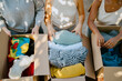 © Maskot - Midsection of multiracial volunteers with boxes of donation goods at community center