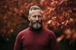 © CogniLens - Portrait of a content man in his 40s showing off a thermal merino wool top isolated on background of autumn leaves