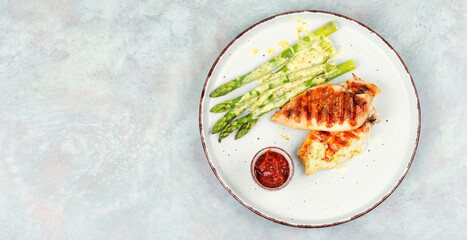 Canvas Print - Chicken fillet cooked on a grill and garnish of asparagus.