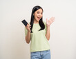 © Chanakon - Pretty young asian woman using cellphone standing on isolated white background. Happy Excited Beautiful young asian shopping online payment with mobile phone. Playing game on smartphone