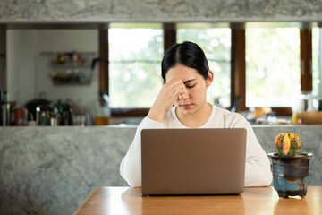 Young asian business woman hand touching head she's feeling depressed stress headache be tired from working with laptop a long time she symptom office syndrome.