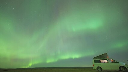 Wall Mural - A small van with an open roof tent under the magnificent aurora skies. A timelapse video.