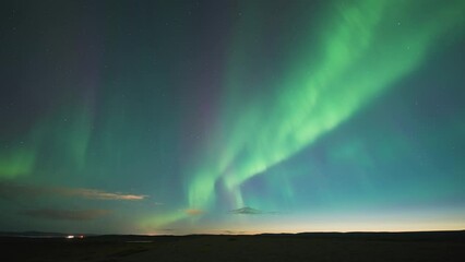 Wall Mural - A spectacular dance of Aurora Borealis in the dark winter sky above the sea. A timelapse video.
