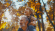 © Mangata Imagine - A happy grandfather is carrying his laughing young grandson on his shoulders in an outdoor park on a sunny day