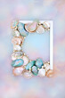 Shell and pearl abstract frame  on rainbow sky background with collection of mother of pearl shells. Natural summer nature design, beach and seaside art.