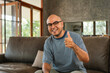 © Chanakon - Handsome asian man sitting rest on sofa couch in living room at home. Happy Portrait of cheerful smiling asian man relax in the house. People quality time and successful in life