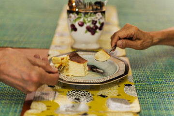 Wall Mural - Senior couple hands with spoon eating burnt cheesecake.