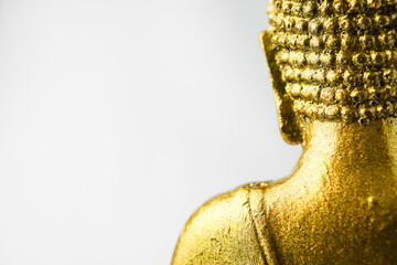 A golden statue of a Buddhist figure meditating facing the back isolated on white background. Bodhisattva Face. Concept for Vesak Day and Enlightenment Day