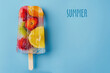 frame of multicolored fruit ice on a stick, on a blue, summer background