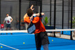 unrecognizable padel player playing padel in a padel court indoor behind the net