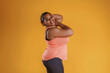 © standret - Standing and posing. African American woman is in the studio against yellow background