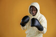 In hood. Boxer is ready to fight. Black guy is against yellow background