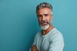 © MediaRaw - A man with a beard and gray hair is standing in front of a blue wall