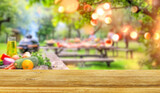 Fototapeta Perspektywa 3d - summer time party in backyard garden with grill BBQ and vegetables, wooden table, blurred background