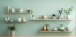 A smooth, pastel mint green wall background, offering a fresh and airy backdrop for a series of minimalist, Scandinavian-style wooden shelves, showcasing a curated selection of pottery and plants
