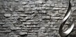 A textured, stone wall background, each stone carefully placed to create a pattern of varying shades of gray, providing a natural and rustic backdrop for a sleek,