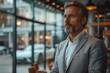 © Vilaysack - Automotive industry CEO in an office with car prototypes on display, looking out the window, contemplative mood, modern office setting