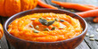 A bowl of pumpkin soup on a blue wooden table Pumpkin, carrot cream soup in a bowl.
