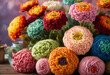 Beautiful vivid colorful knitted dahlias and aster flowers made yarn on wooden deck. Wool floral decoration.