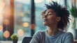 © Justlight - A person sits at their desk with their eyes closed taking a break from work to refocus and engage in mindful breathing.