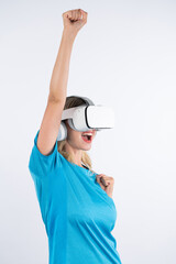 Wall Mural - Caucasian happy girl wearing VR glasses and making winner gesture. Skilled woman celebrate while winning game by using VR headsets and standing at pink background. Technology innovation. Contraption.