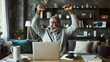 © Elena - Man exuding joy and triumph in front of a laptop screen, celebrating success and happiness